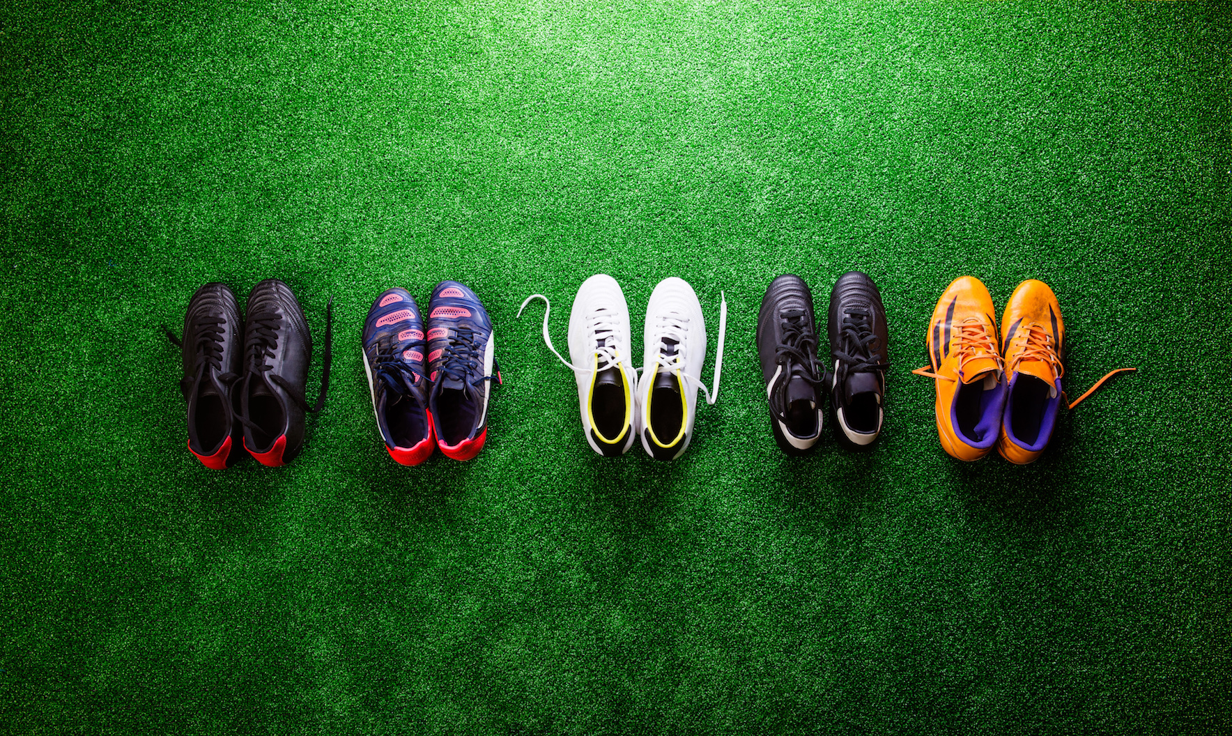 Football boots and trainers on grass