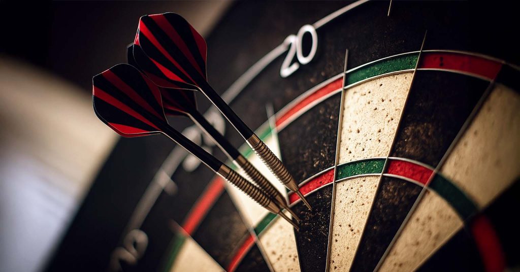 Darts hitting the bullseye target.