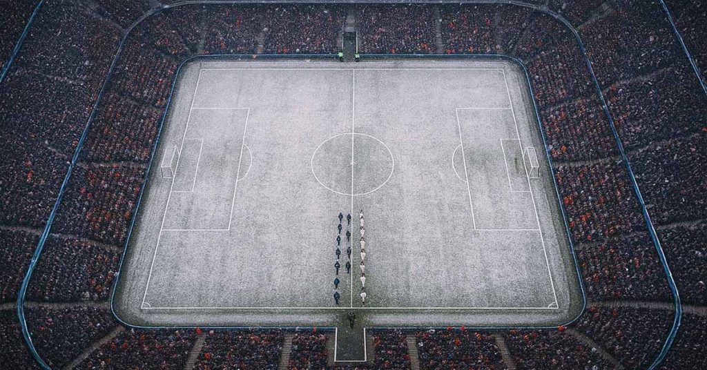 Snow-covered pitch with spectators watching