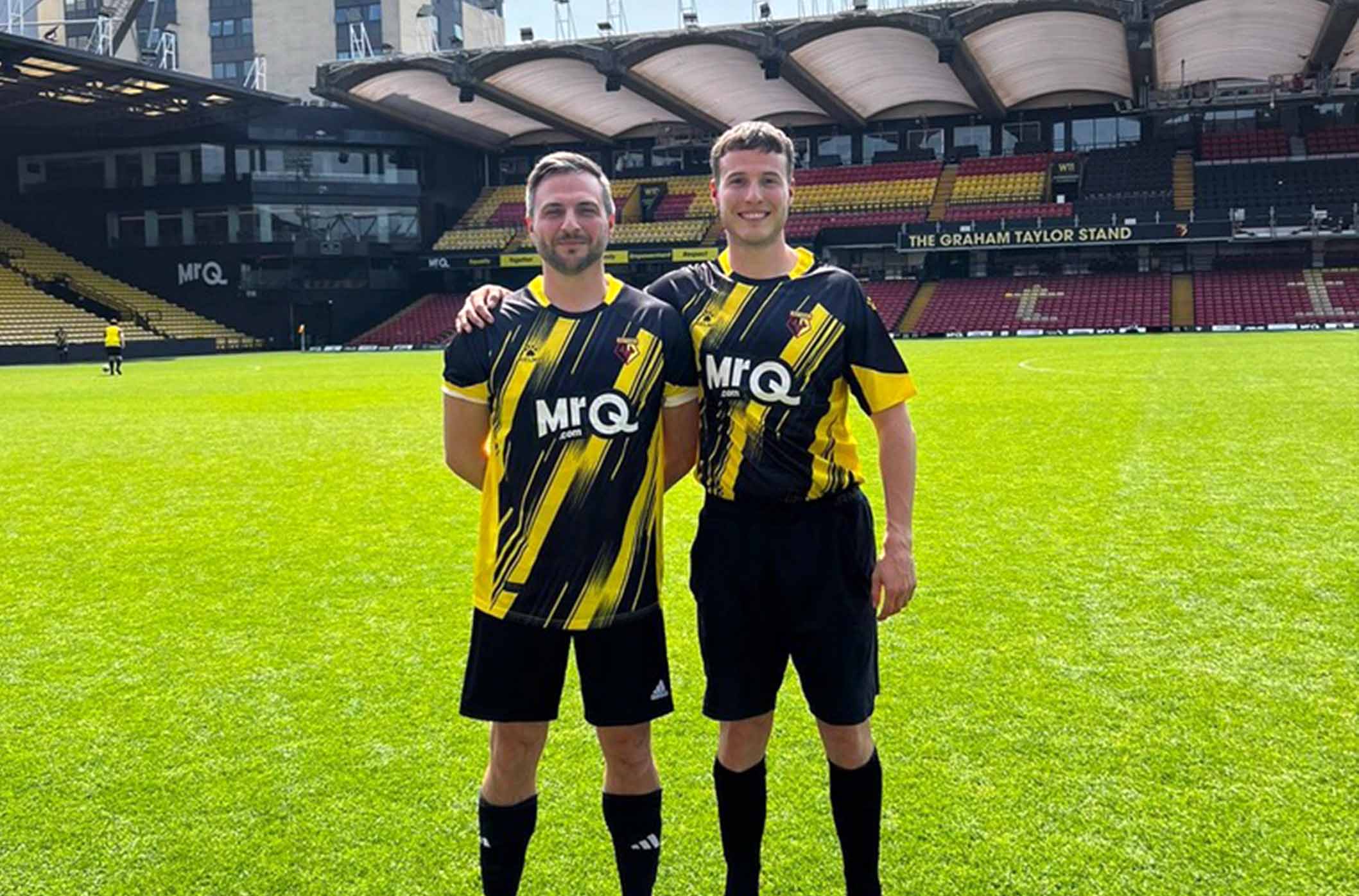 Two players in football kits posing.