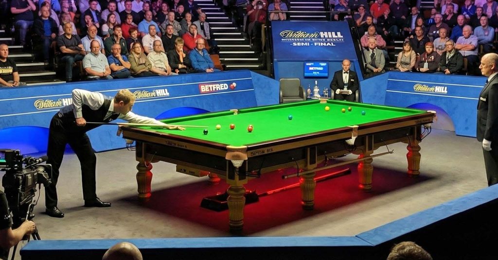 Snooker match in a crowded venue.